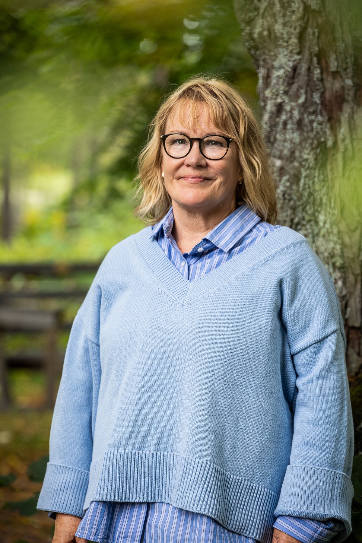 Muotokuva Sari Siltavuoresta puistossa puun vierellä.